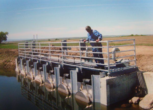 A man standing on top of installed aluminum flat irrigation screen