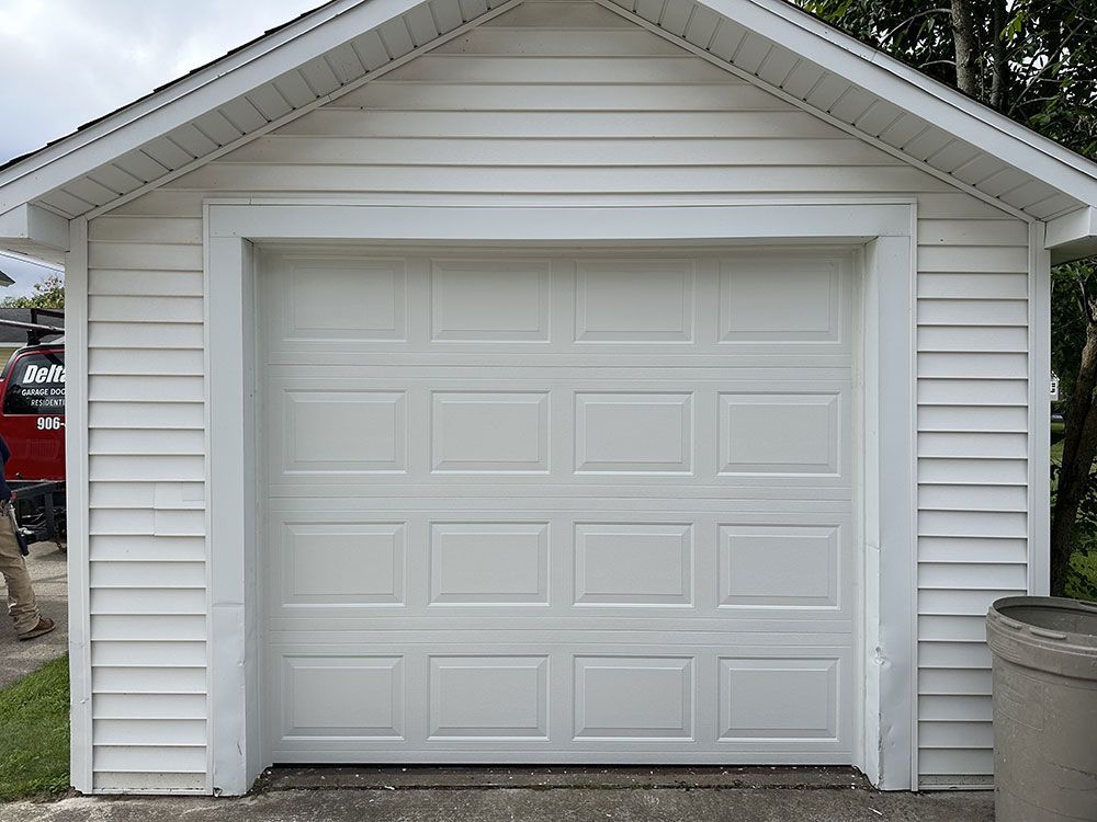 A white garage with a roof and a white door