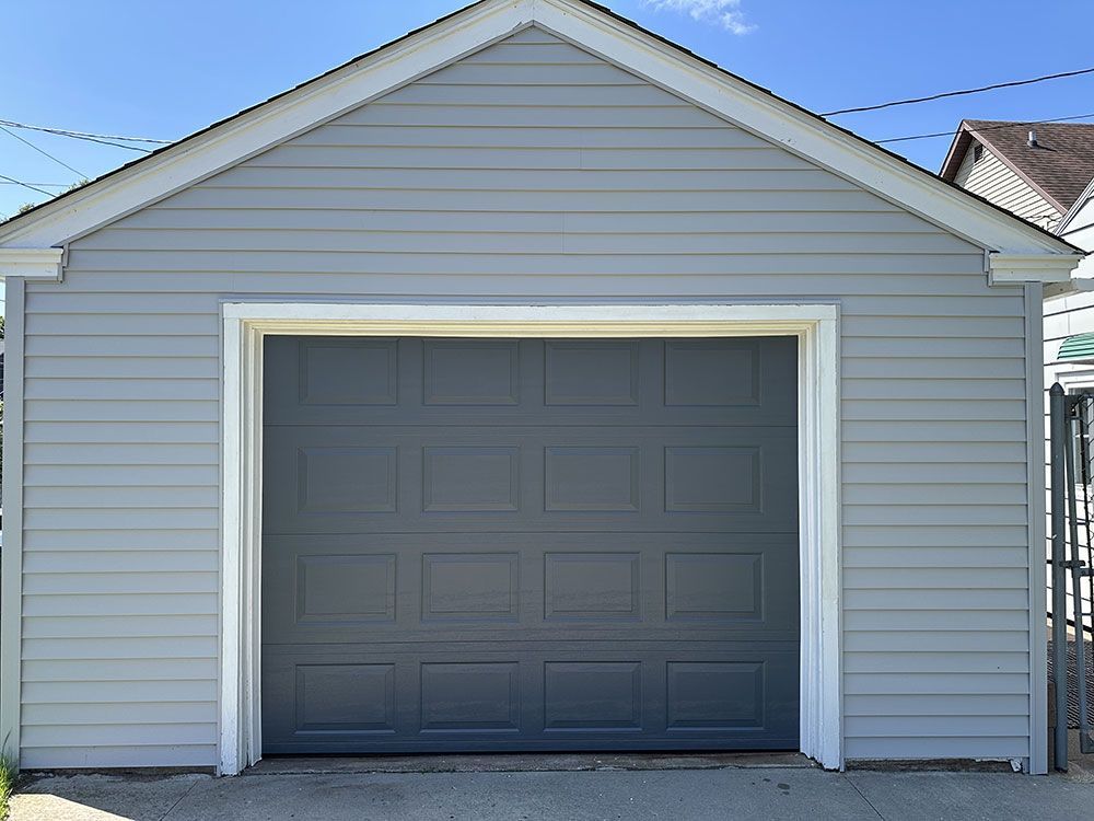 A garage with a gray garage door and a white trim