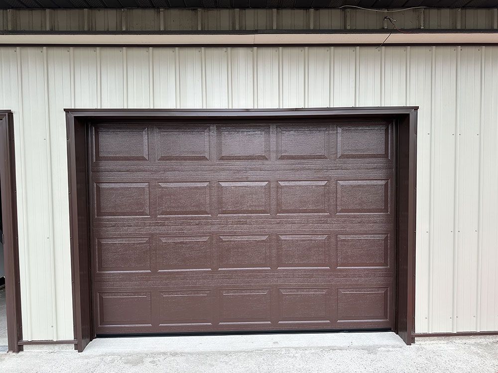 A brown garage door on a white building