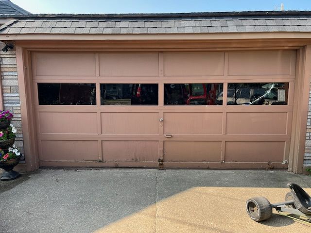 A pink garage door with a cart parked in front of it.