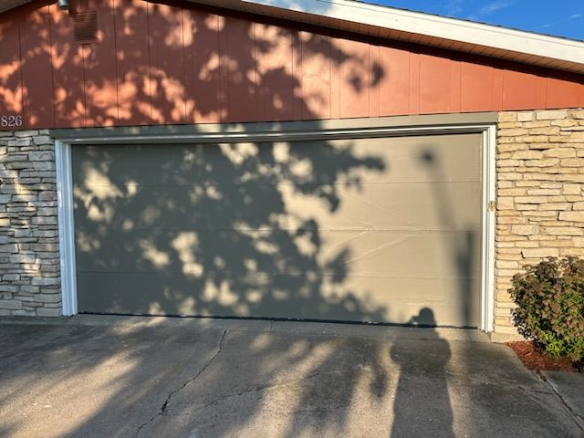 A garage door with a tree shadow on it