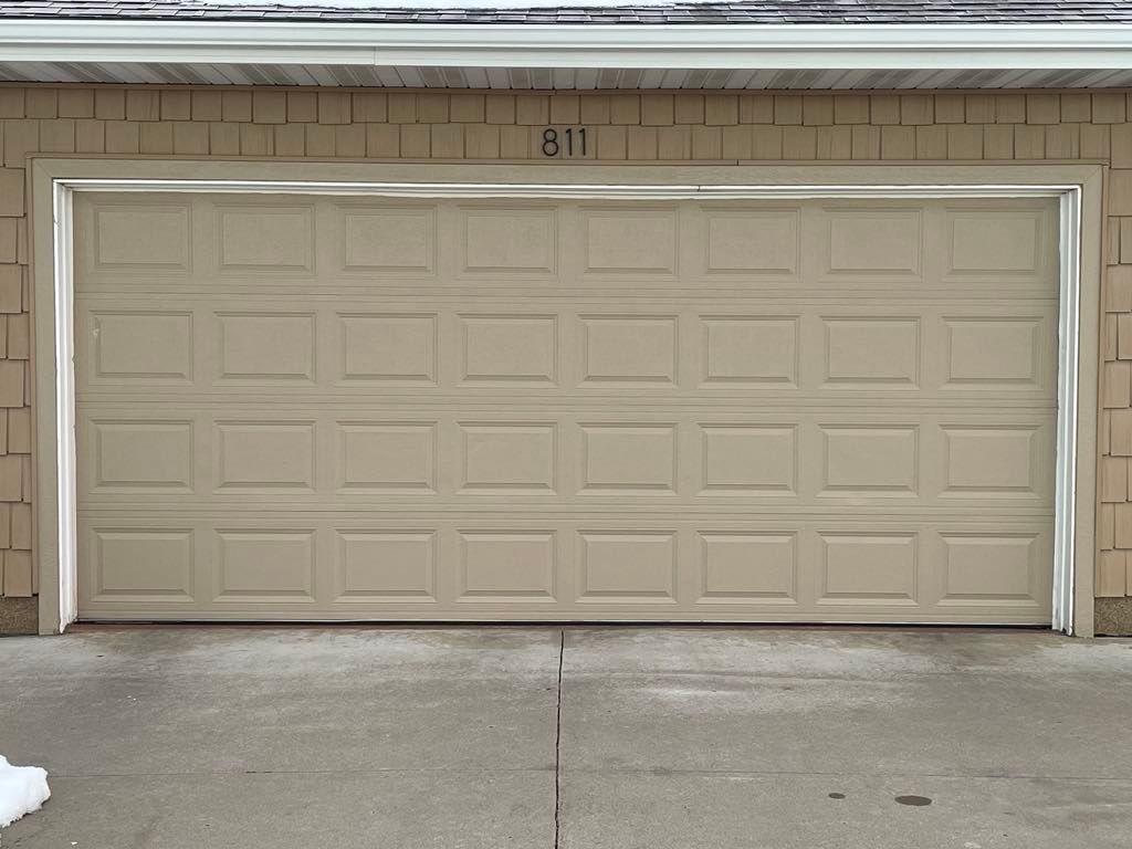 A tan garage door with the number 311 on it