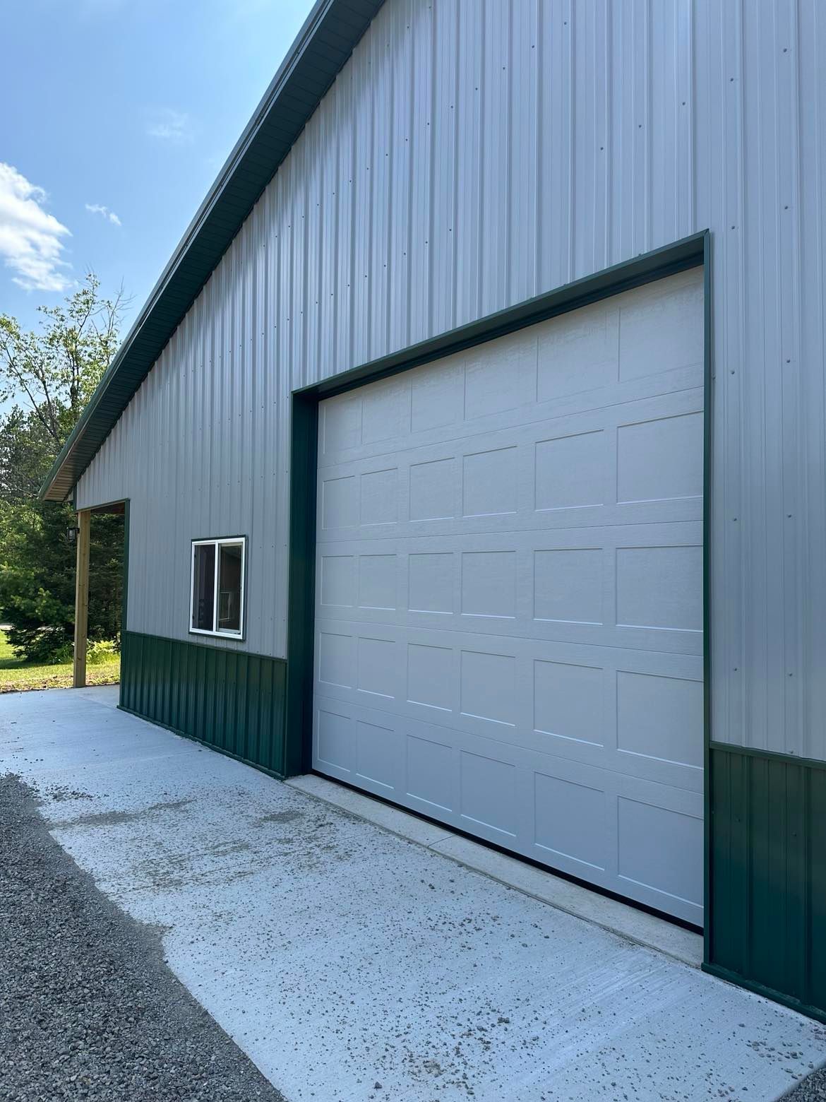 A garage with a white garage door and a green trim.