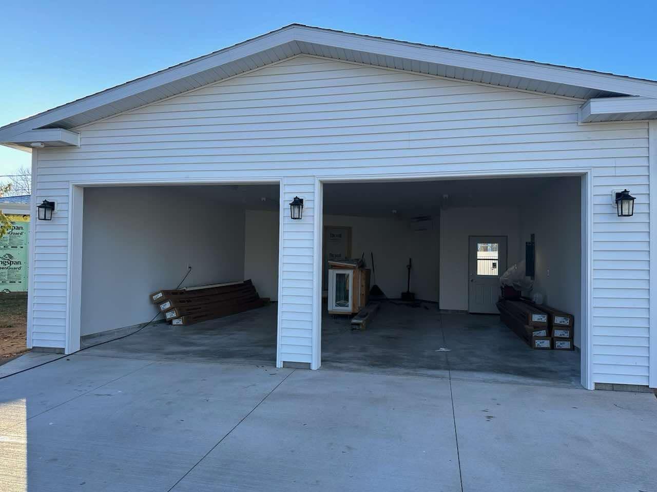 A white garage with two doors is being built.
