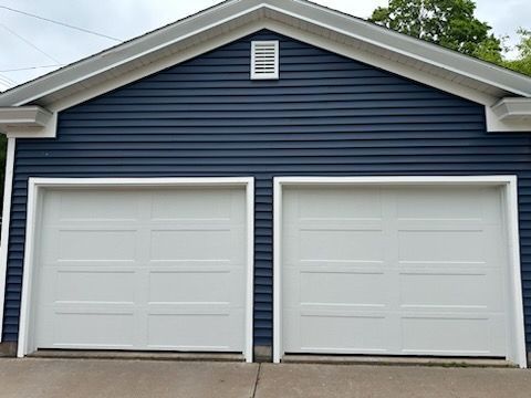 A blue and white garage with two white garage doors.