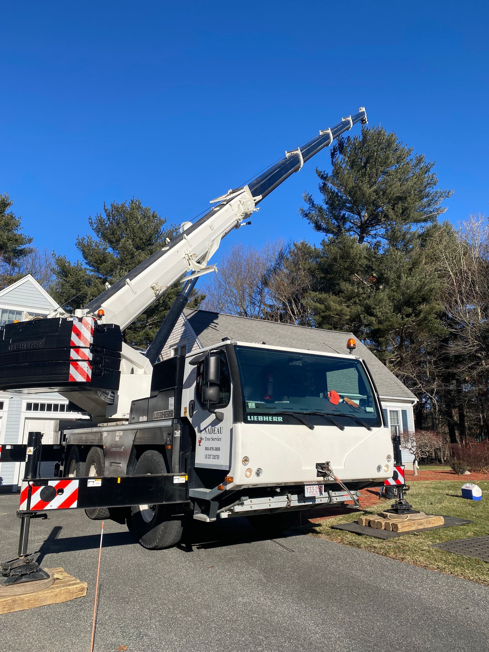 A large white crane is parked in front of a house.
