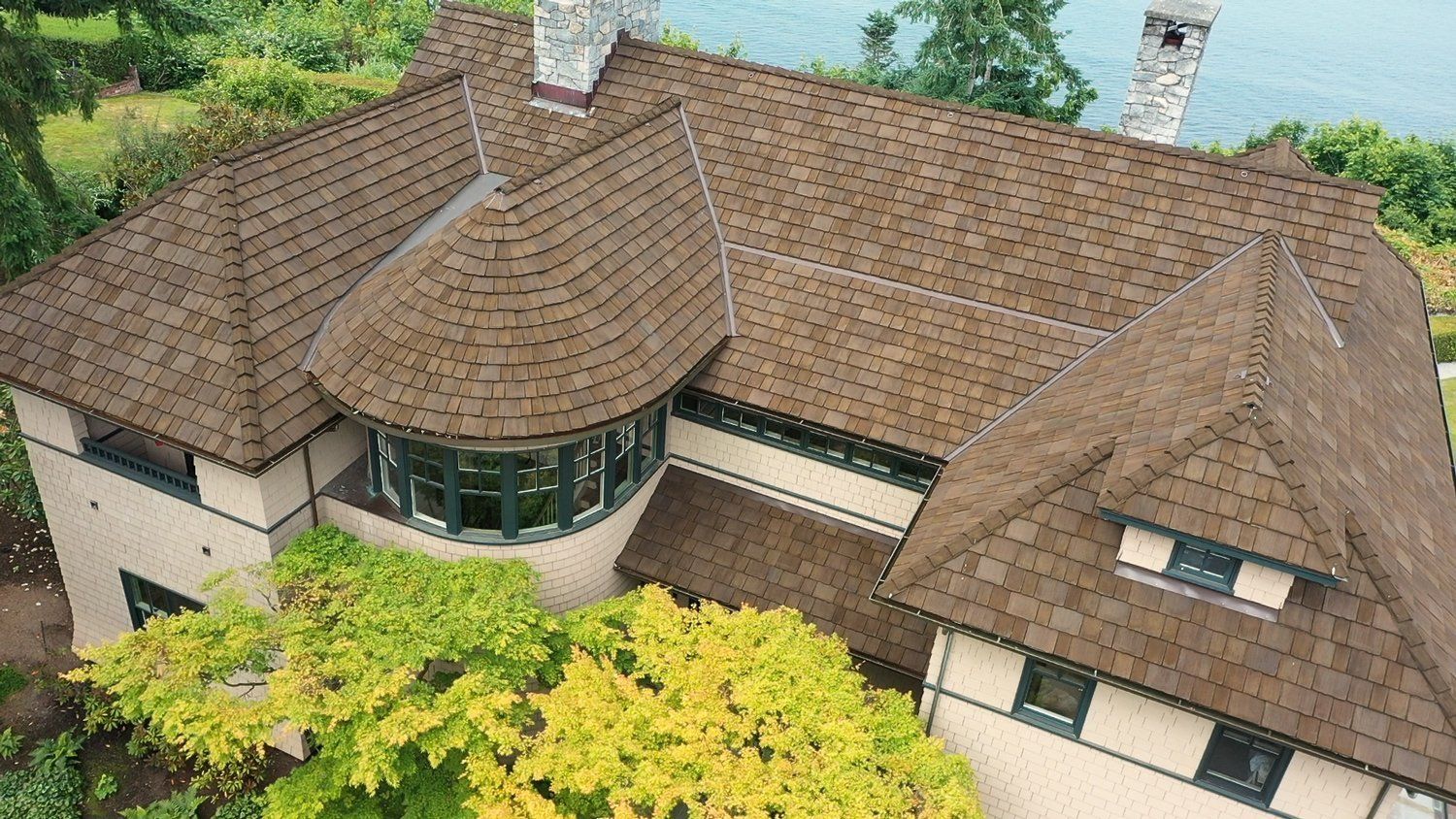 An aerial view of a large house with a brown roof