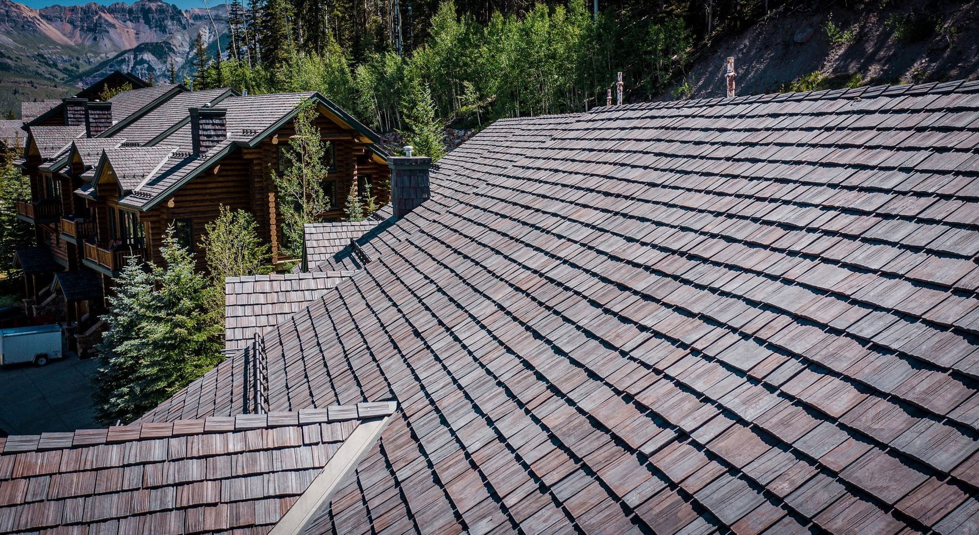 A close up of a wooden roof with a mountain in the background.