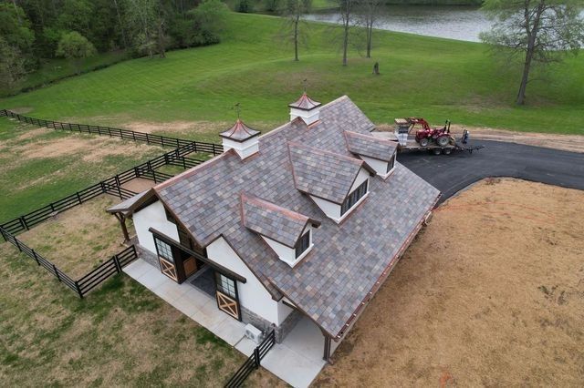 An aerial view of a house with a tractor parked in front of it.