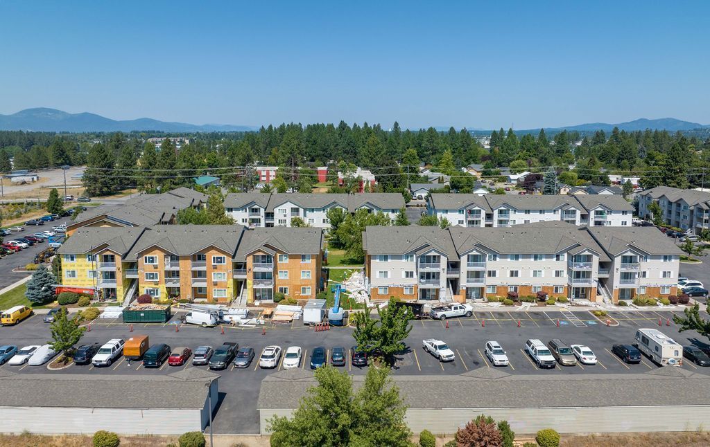 An aerial view of a large apartment complex with cars parked in front of it
