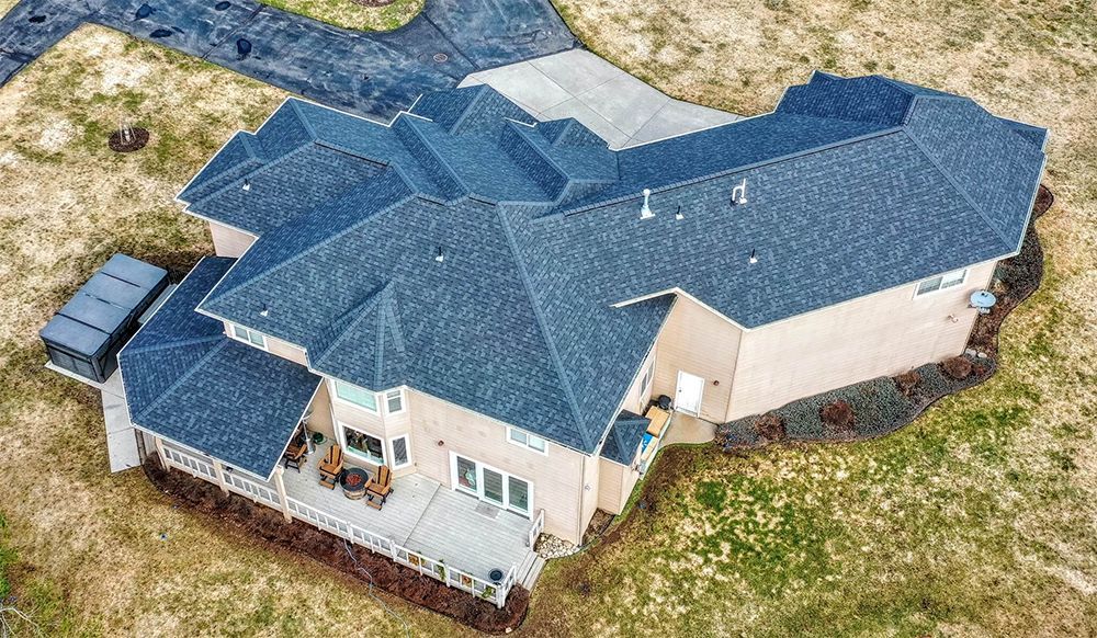 An aerial view of a large house with a blue roof
