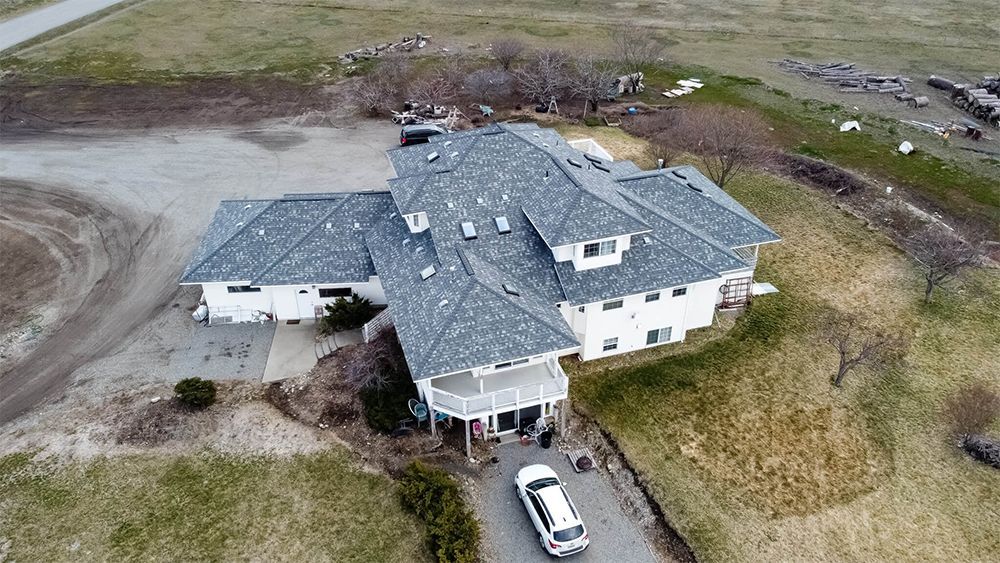 An aerial view of a large house with a car parked in front of it