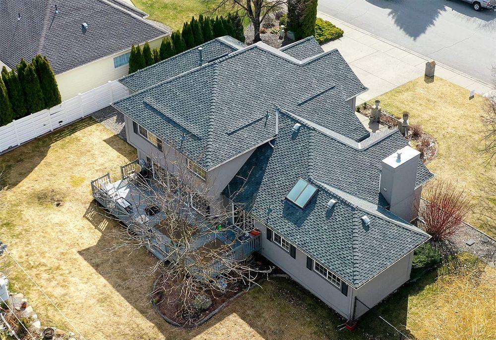An aerial view of a large house with a gray roof