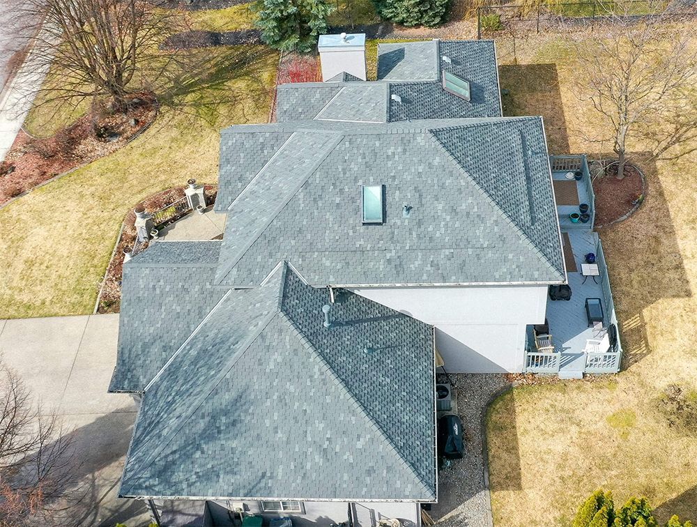 An aerial view of a large house with a gray roof