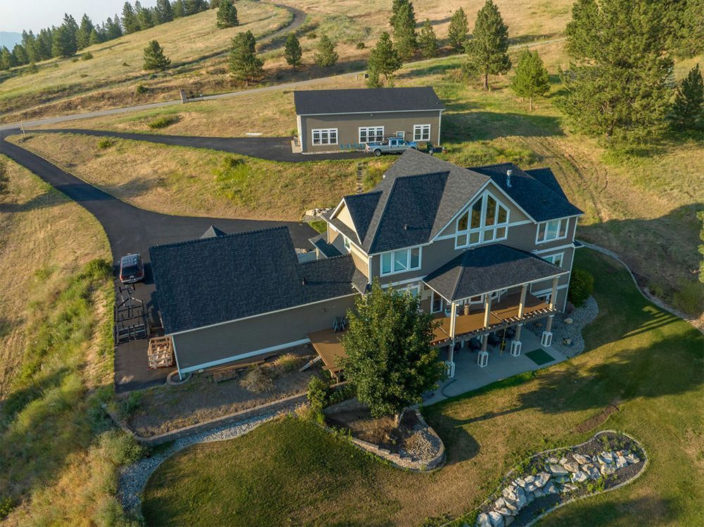 An aerial view of a large house sitting on top of a hill