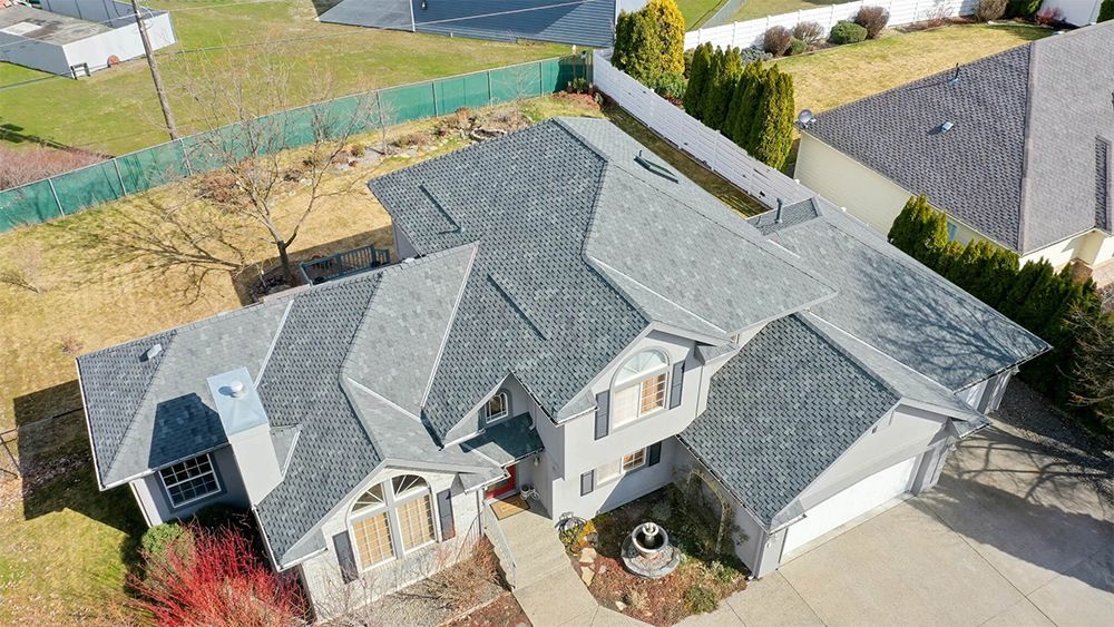 An aerial view of a large house with a gray roof