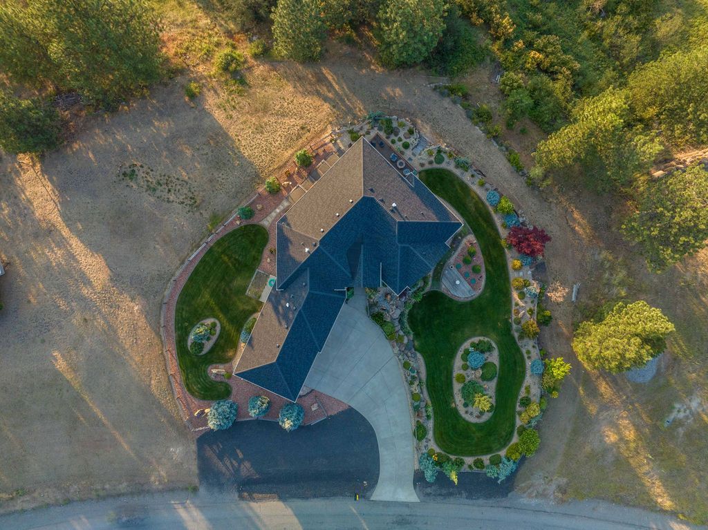 An aerial view of a house surrounded by trees and grass