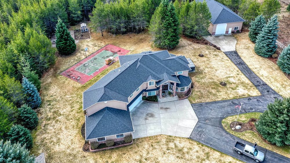 An aerial view of a large house surrounded by trees