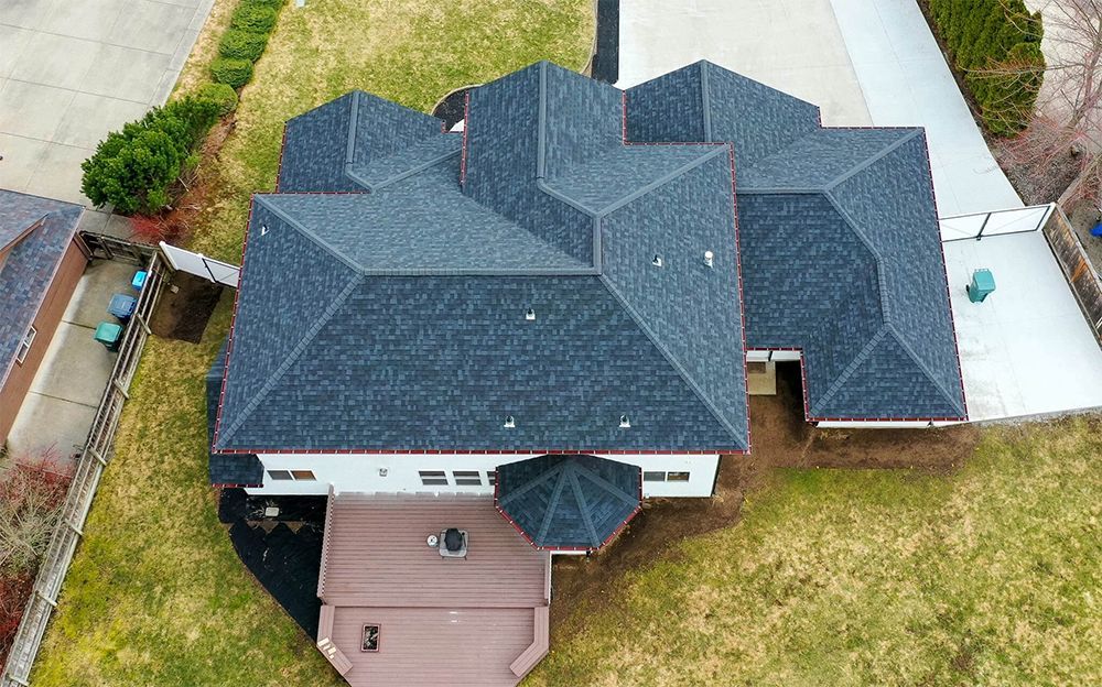 An aerial view of a large house with a black roof