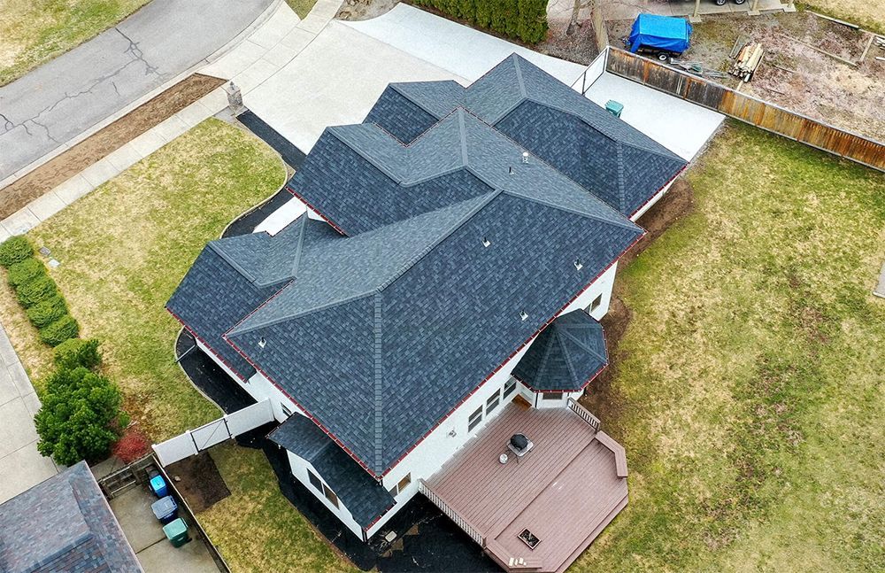 An aerial view of a large house with a black roof