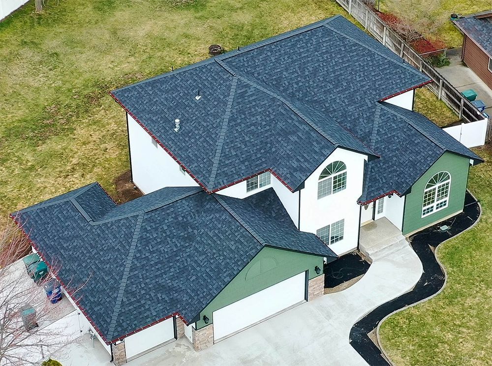 An aerial view of a large house with a blue roof