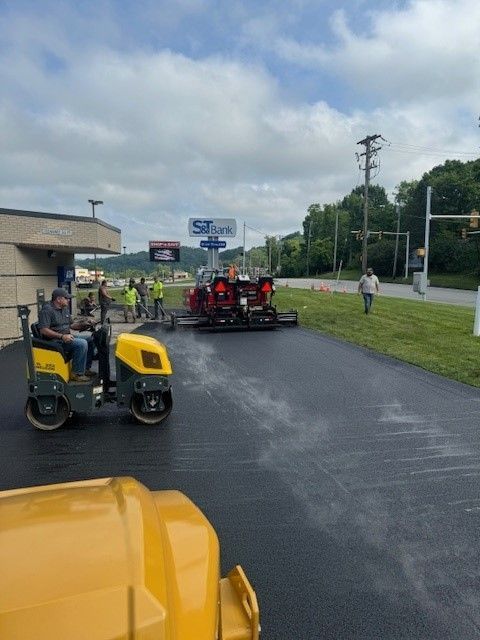 a yellow truck is driving down a road next to a sign of a commercial building