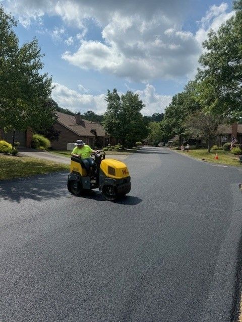 a man is riding a yellow tractor down a street