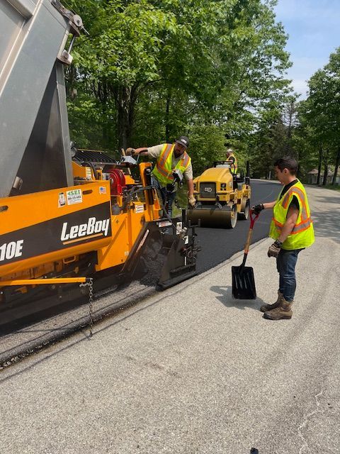 a group of construction workers are working on a road
