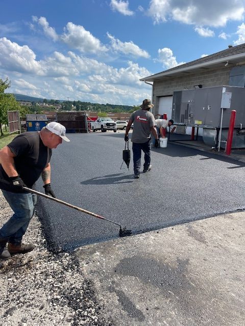 two men are working on a driveway in front of a building