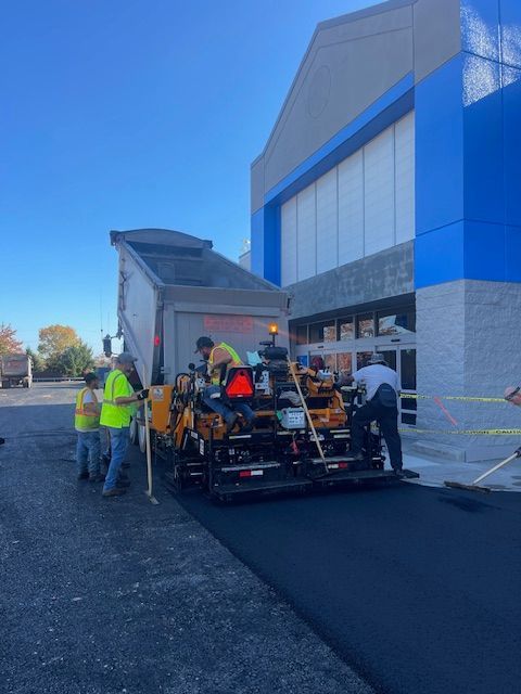 a group of men are working on a road in front of a building