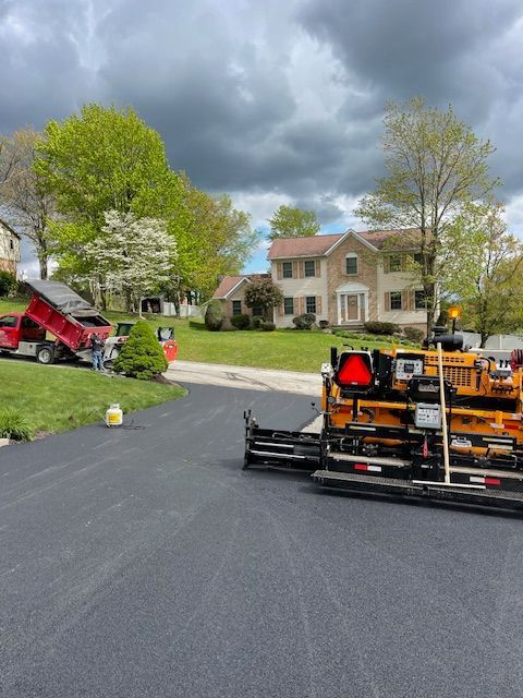 laying asphalt on a driveway in front of a house