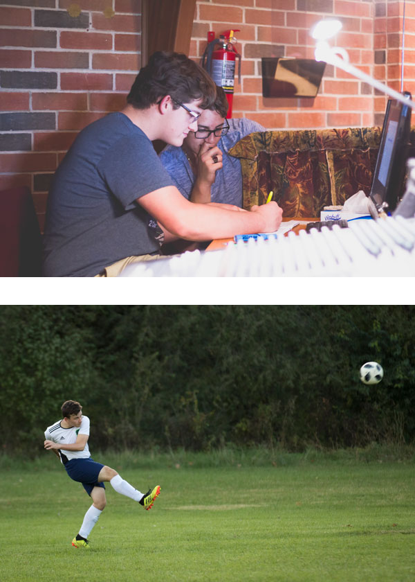 A man is sitting at a desk and a man is kicking a soccer ball.