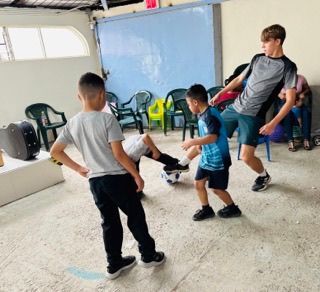 A group of young boys are playing soccer in a room.