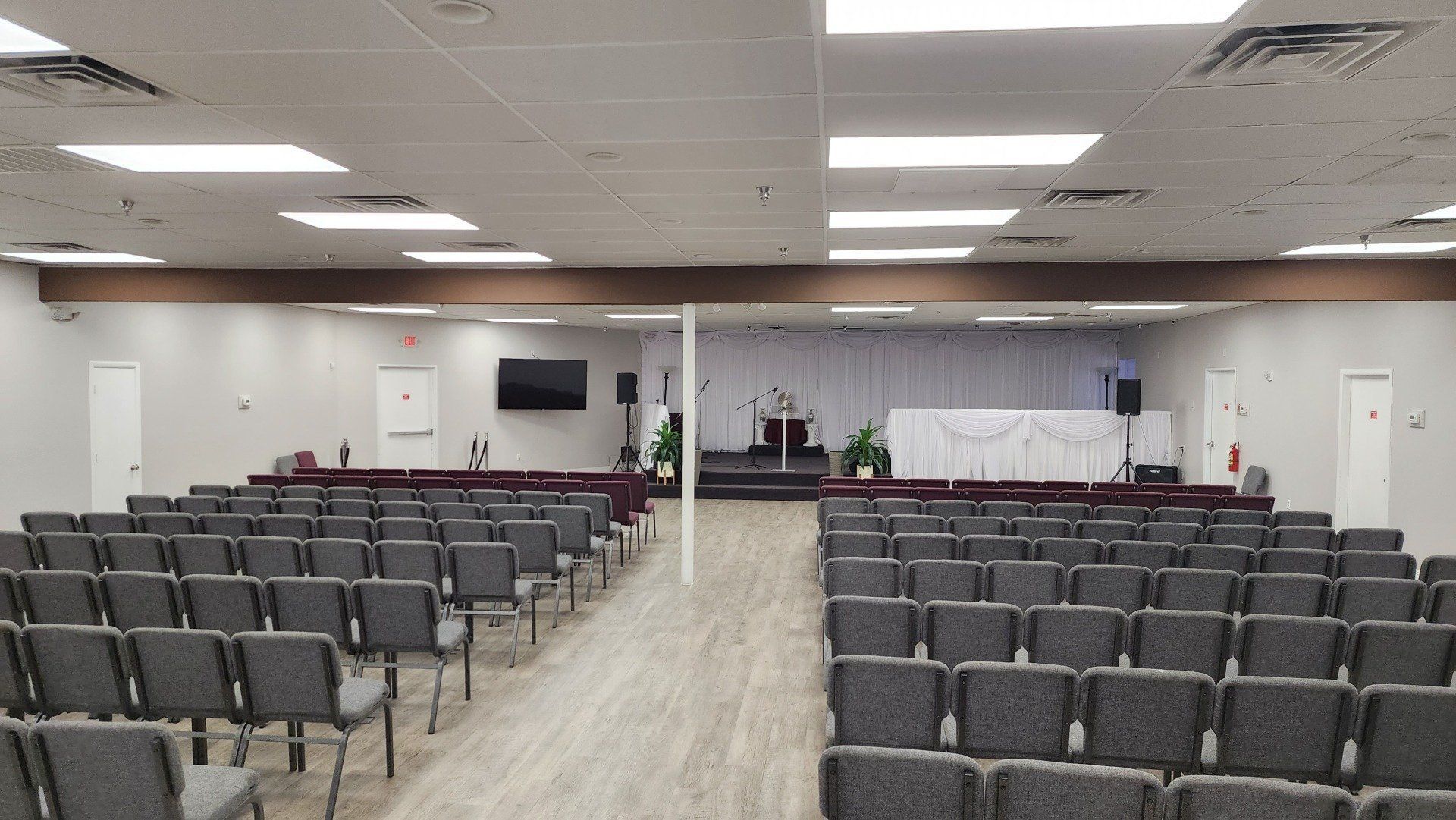 A large room filled with rows of chairs and a stage.