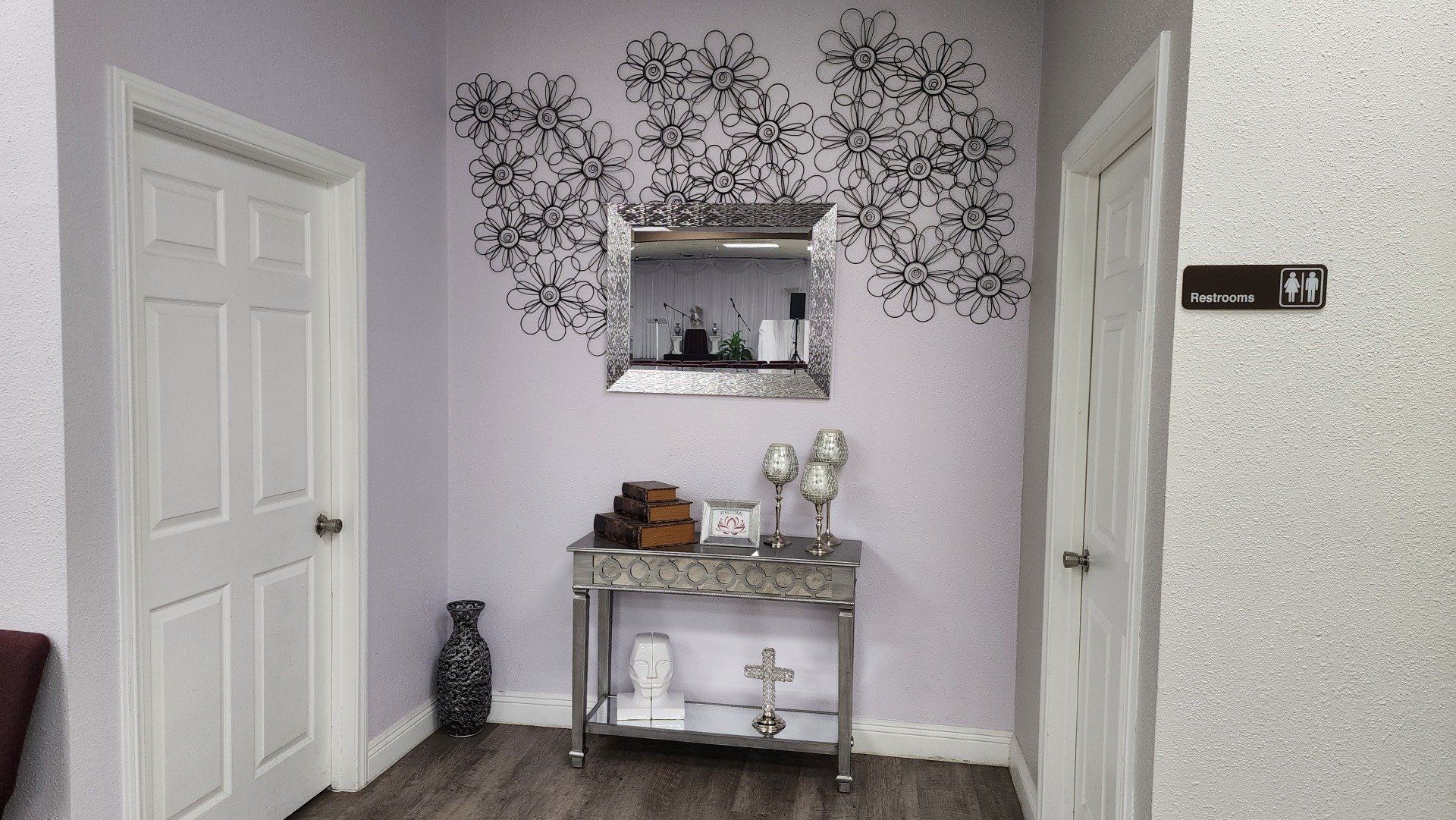 A hallway with a table and a mirror on the wall.