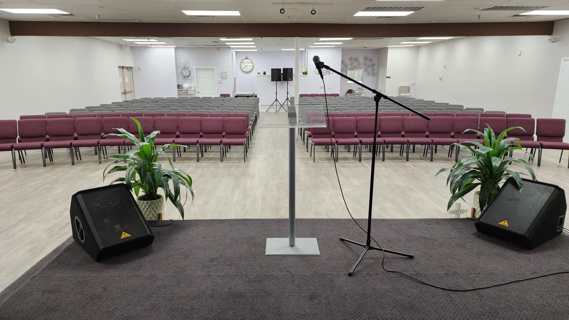 A large room with rows of chairs and a microphone on a stage