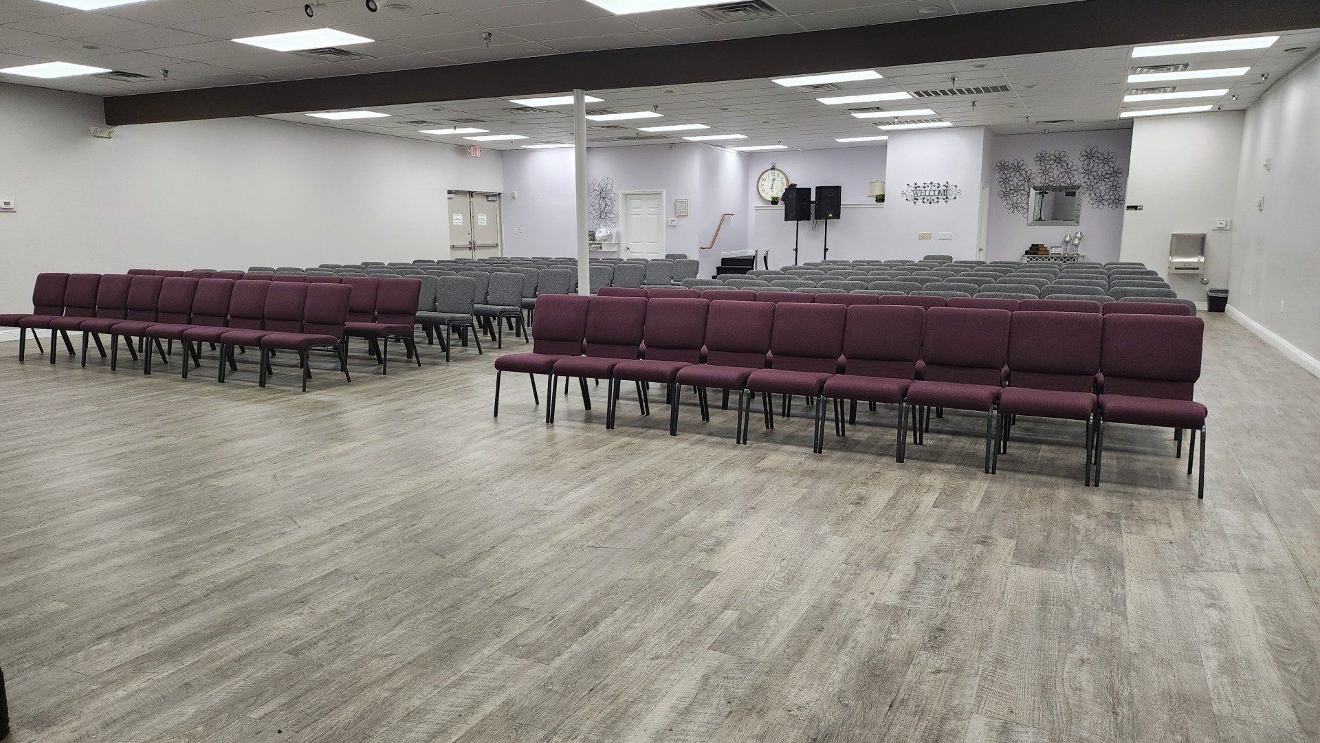 A large room with rows of purple chairs in it.