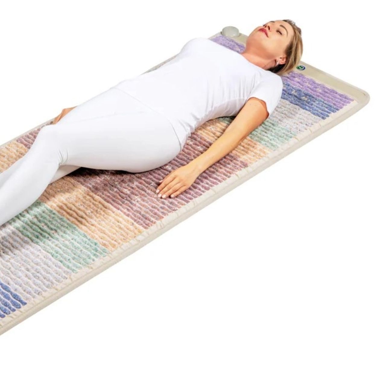 A woman in white laying on a colorful mat