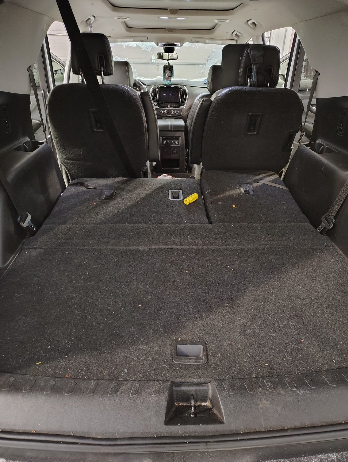 A view inside the cargo area of an SUV with the rear seats folded flat, showing dark gray carpet and interior upholstery.