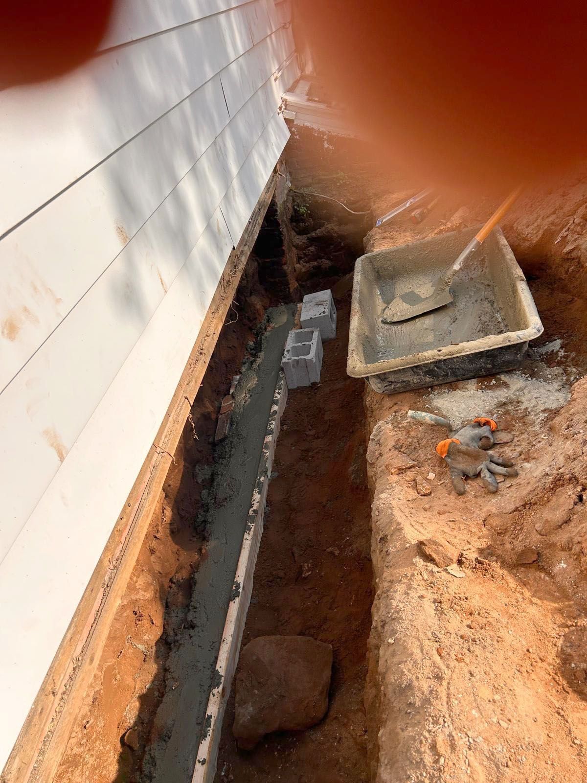 Construction site with trench next to a wall