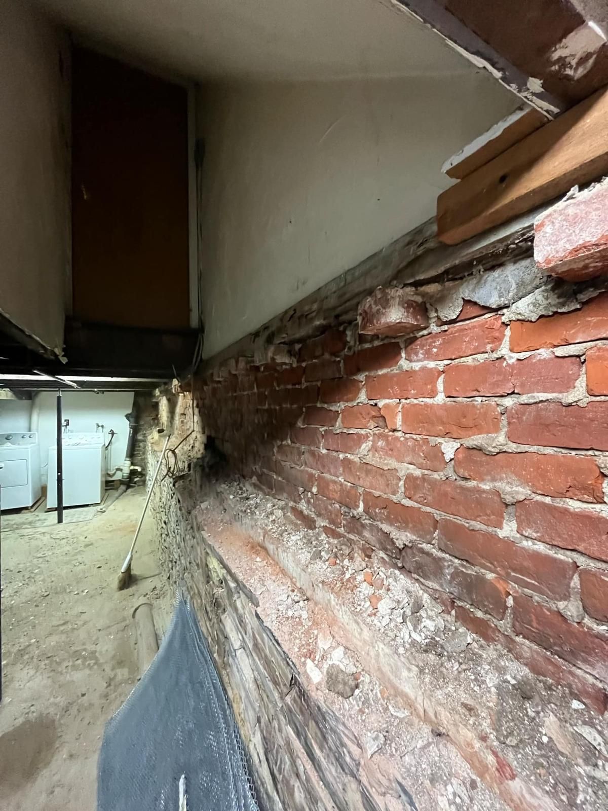 Brick wall with wood, possible water damage; interior view.