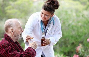 A doctor giving medicine to an old man