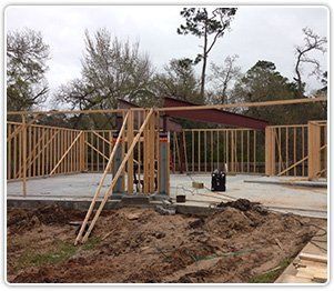 A construction site shows a partially framed house on a concrete foundation with a prominent steel I-beam.