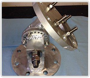 A metal swivel pipe assembly with circular flanges, threaded studs, and welded joints on a blue surface.