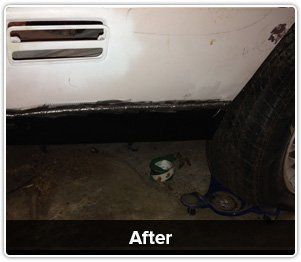 A car's lower side panel after repair, showing a freshly welded, painted black rocker panel beneath a white body.