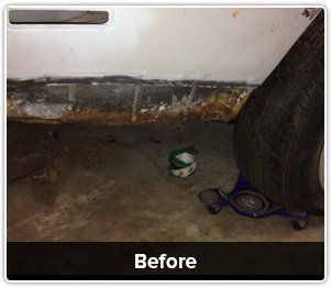 A close-up of a rusted car rocker panel near a tire with a jack stand visible on a garage floor, labeled 