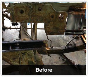A close-up of a damaged, rusted vehicle frame in a workshop, labeled with the word 
