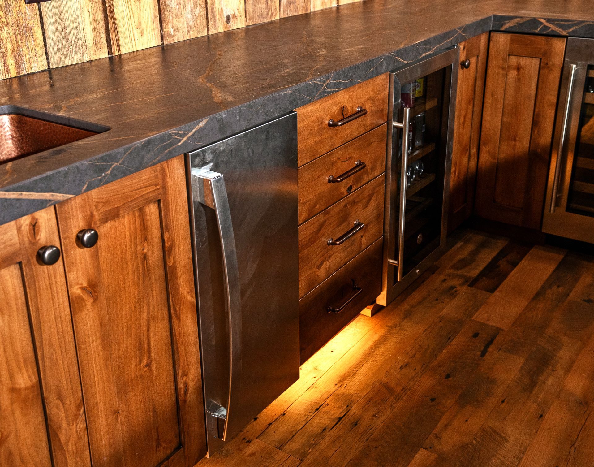 Wooden kitchen cabinets with stainless steel appliances and dark countertops.