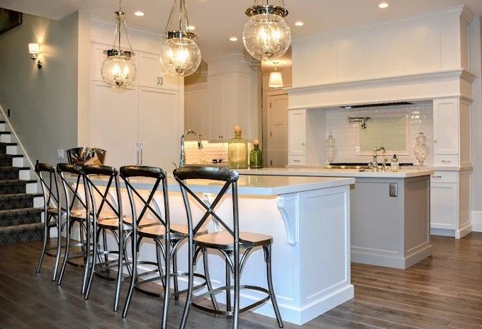 Elegant kitchen with a large island, pendant lights, and bar stools.